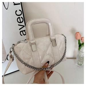 Detail of white quilted Boston bag with silver chain strap and shiny PU leather finish