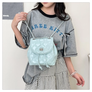 Quilted light blue leather backpack with metal chain straps shown on a model