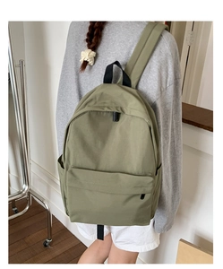 Olive green nylon backpack showing side view and comfortable wide shoulder strap detail