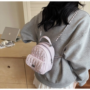 Macro detail of pink quilted mini backpack with sparkling crystals and silver chain strap