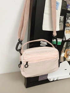 Pink checkered crossbody bag with double zippers and black round pullers for women