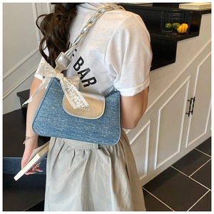 Détail du sac à paillettes bleues avec rabat argenté et nœud en dentelle blanche