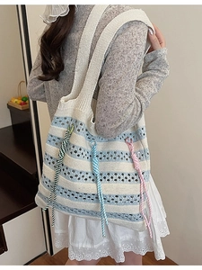 Large knitted tote bag with blue stripes and colorful rope charms for summer beach trips