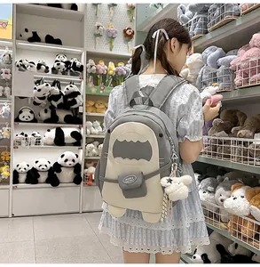 Detailansicht eines grauen Haifisch-Rucksacks aus Canvas mit Flossen und Plüsch-Anhänger
