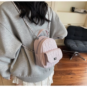 Close-up of pink quilted PU leather backpack with rhinestones and metal chain strap