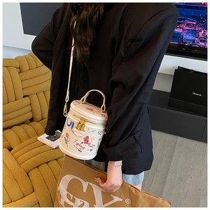 Detail of white graffiti bucket bag with adjustable strap worn on model shoulder
