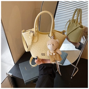 Détail du mini sac seau jaune clair tressé avec bandoulière et charmant petit ours
