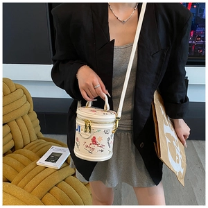 Chic graffiti bucket bag styled with a blazer to show scale and urban fashion vibe