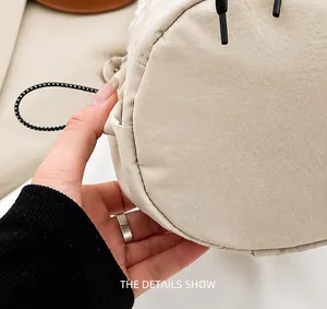Detail shot of precise stitching and durable fabric texture on light beige bucket bag