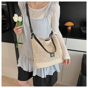Détail du sac de plage tressé beige ajouré avec bandoulière réglable en cuir noir