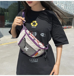 Detail of white nylon crossbody bag with purple webbing and black mesh pocket