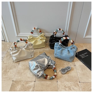 Detailed display of five colorful drawstring bucket bags with unique resin bead handles