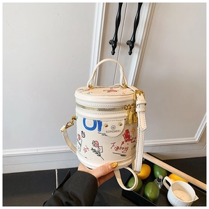 Close-up of white bucket bag featuring colorful cartoon graffiti and gold hardware accents
