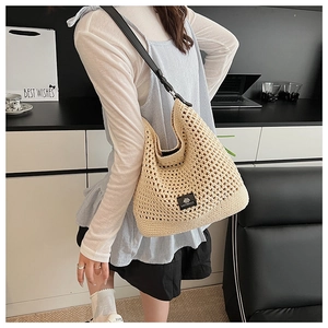 Détail du sac tissé ajouré avec bandoulière noire et étiquette de logo carré