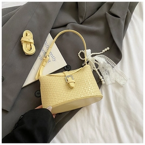 Détail du sac seau tissé jaune avec boucle argentée et bandoulière réglable pratique