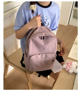 Detail of light purple canvas backpack showing large main compartment and metal zipper