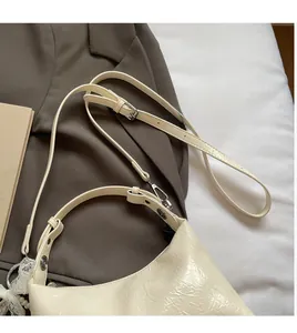 Détail du sac à bandoulière en cuir plissé blanc crème avec dentelle et perle décorative