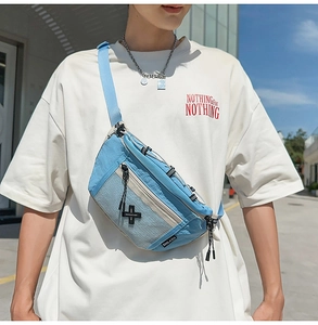 Close-up of light blue sports chest bag with white mesh pocket on a model outdoors