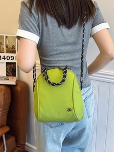 Minimalist neon green nylon backpack with woven handles and crossbody strap for travel