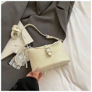 Détail du sac à main tissé blanc cassé avec nœud en dentelle perlée et bandoulières réglables