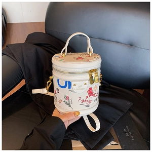 Detail view of white cylinder bucket bag with colorful graffiti art and gold zipper