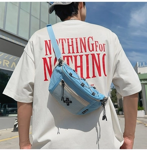 Rear view of a blue sports crossbody bag with mesh pockets worn by a model in the street