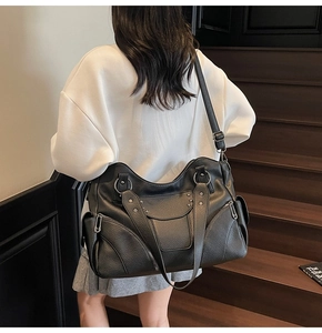 Détail d'un grand sac cabas en cuir noir à rivets avec des bandoulières réglables