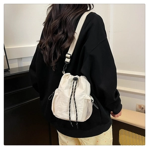 Weiße Nylon-Beuteltasche mit Kordelzug und verstellbarem Riemen über der Schulter