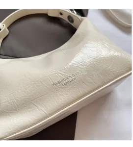 Détail de la texture cuir PU plissé beige avec lettrage argenté Fashion & Bags gaufré
