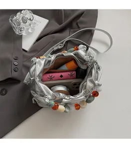 Top view of silver pleated bucket bag showing spacious interior with phone and wallet