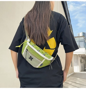 Detail showing the green nylon crossbody bag with mesh pocket and yellow elastic cord detail