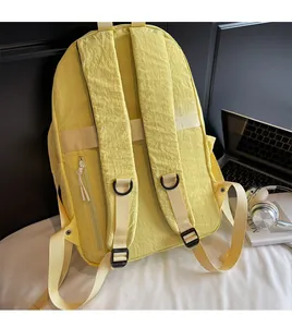 Rear view of yellow nylon backpack featuring wide padded straps and a hidden side pocket