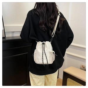 Detailansicht der weißen Nylon-Beuteltasche mit Netztasche und schwarzem Gurt