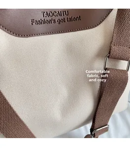 Close-up of premium off-white canvas and dark brown leather stitching on tote bag