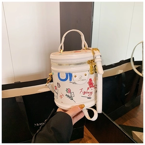 Detailed close-up of white leather bucket bag featuring colorful hand-drawn graffiti art