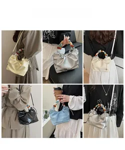 Fashionable pleated bucket bags with colorful beaded handles shown in five vibrant colors