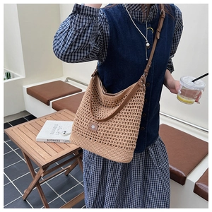 Détail du sac tricoté évidé avec bandoulière réglable en cuir marron de haute qualité