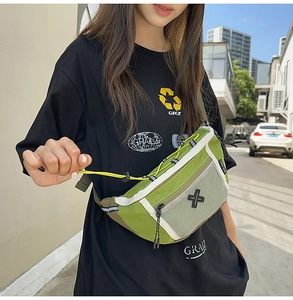 Detail of green nylon crossbody bag with white mesh pocket and cross logo on street model