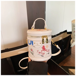 Detail of white cylinder bucket bag with colorful graffiti and gold double zipper