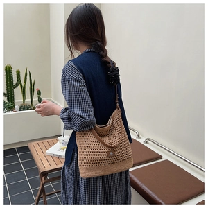 Détail d'un sac bandoulière au crochet marron avec lanière en cuir sur un mannequin