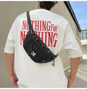 Rear view of model wearing a black nylon crossbody bag with tactical cord and mesh