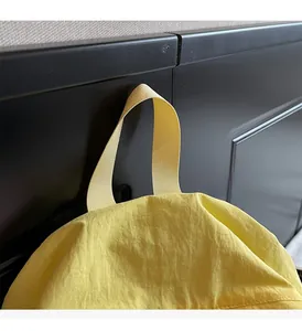 Detailed view of the reinforced yellow nylon handle and stitching on the casual backpack