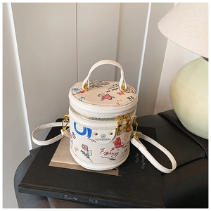 Detail of colorful graffiti patterns and metallic brand logo on a white bucket handbag