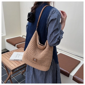 Vue détaillée de la texture tissée et de la bandoulière en cuir du sac en paille