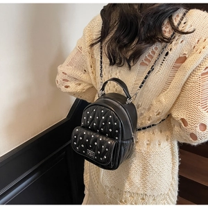 Detail view of mini quilted leather backpack with rhinestones and chain straps on model