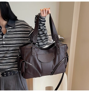 Gros plan du sac cabas marron foncé avec rivets étoiles et fermetures éclair fonctionnelles