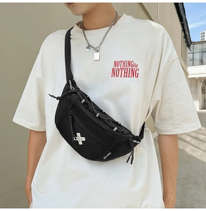 Detail of durable black nylon crossbody bag with mesh pocket and reflective zipper pulls
