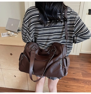 Détail du sac cabas en cuir marron foncé avec fermeture éclair et bandoulière réglable