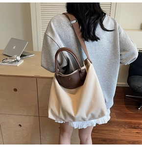 Close-up of canvas tote bag with leather handles shown in a lifestyle office setting