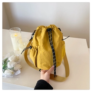 Detail einer hellgelben Nylon-Beuteltasche mit Netztasche und Kordelzugverschluss